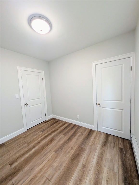 121 Whitman Street, Unit 2 New Bedford, MA 02745 - Photo 7 of 11 a view of a room with wooden floor and white doors