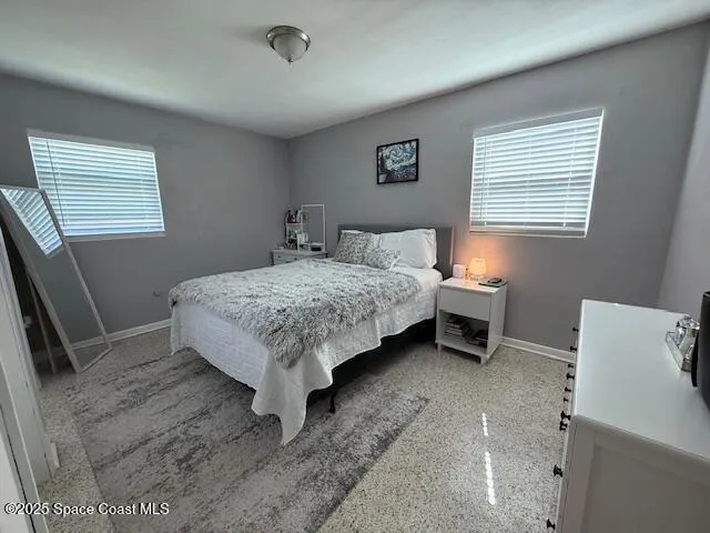 a bedroom with a bed and a mirror on dresser