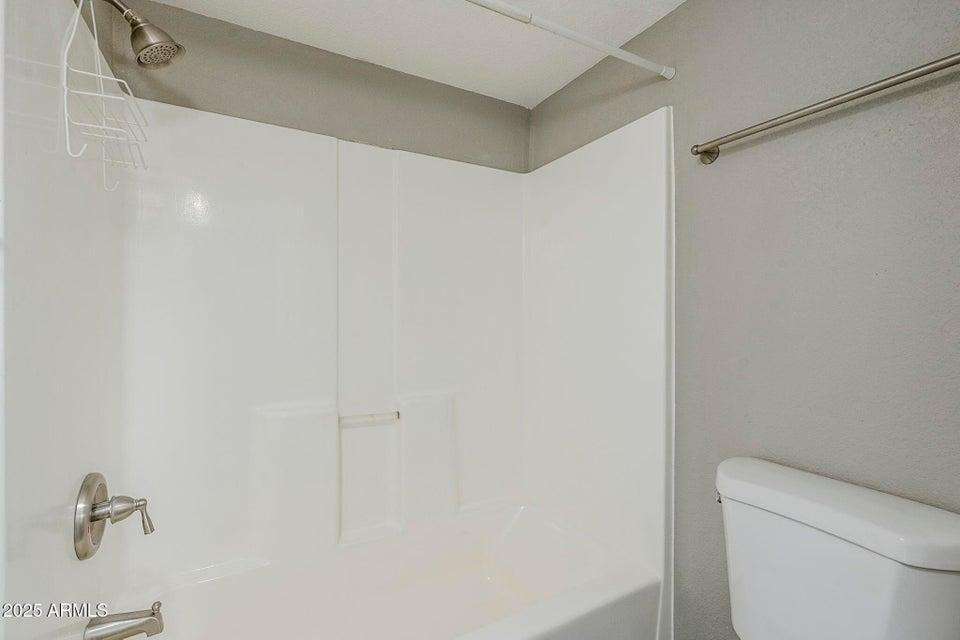 1826 N Spring, Unit 201 Mesa, AZ 85203 - Photo 13 of 17 a white toilet sitting next to a shower