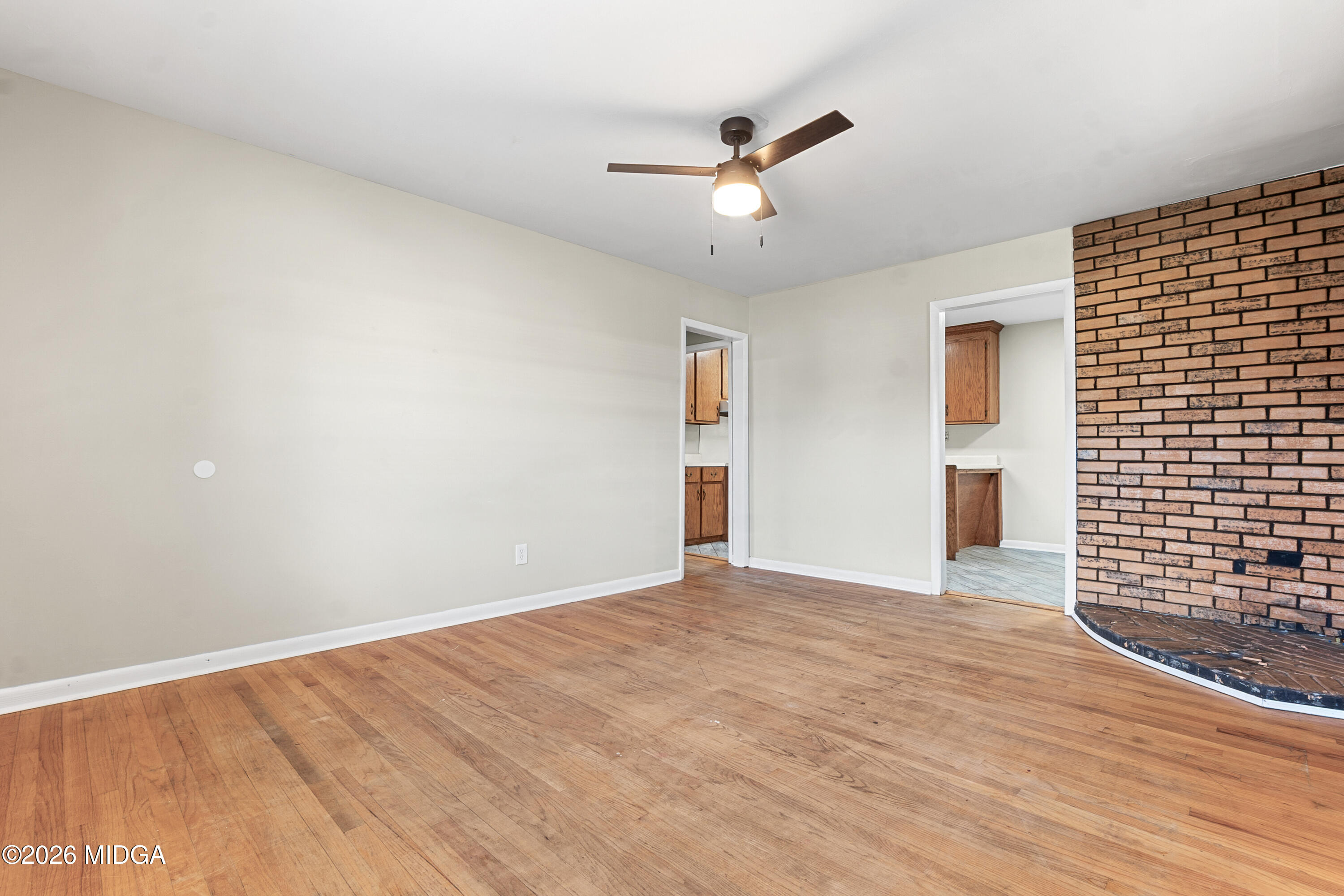 112 Athens Street Warner Robins, GA 31088 - Photo 6 of 42 a view of an empty room with wooden floor and a ceiling fan