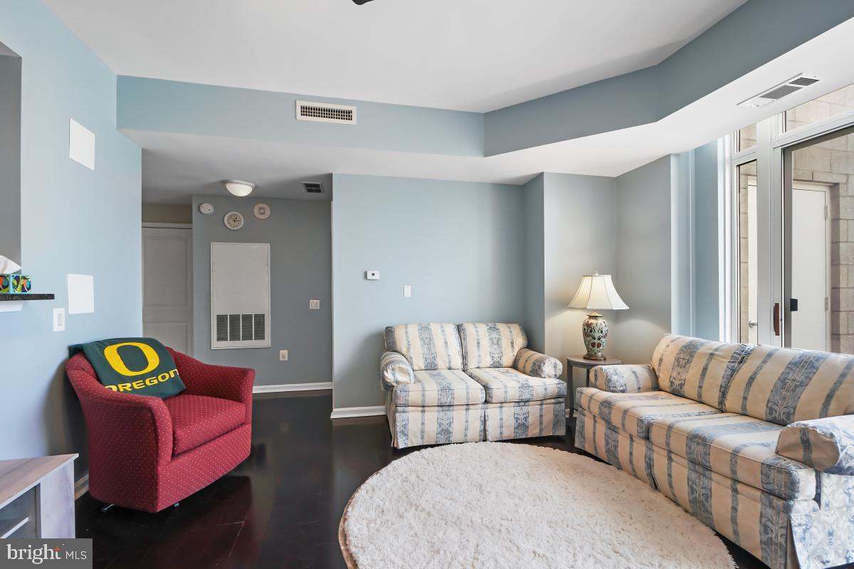 930 Wayne Avenue, Unit 1407 Silver Spring, MD 20910 - Photo 12 of 31 a living room with furniture and a lamp