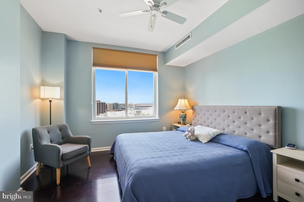 930 Wayne Avenue, Unit 1407 Silver Spring, MD 20910 - Photo 21 of 31 a bedroom with a bed and a chandelier