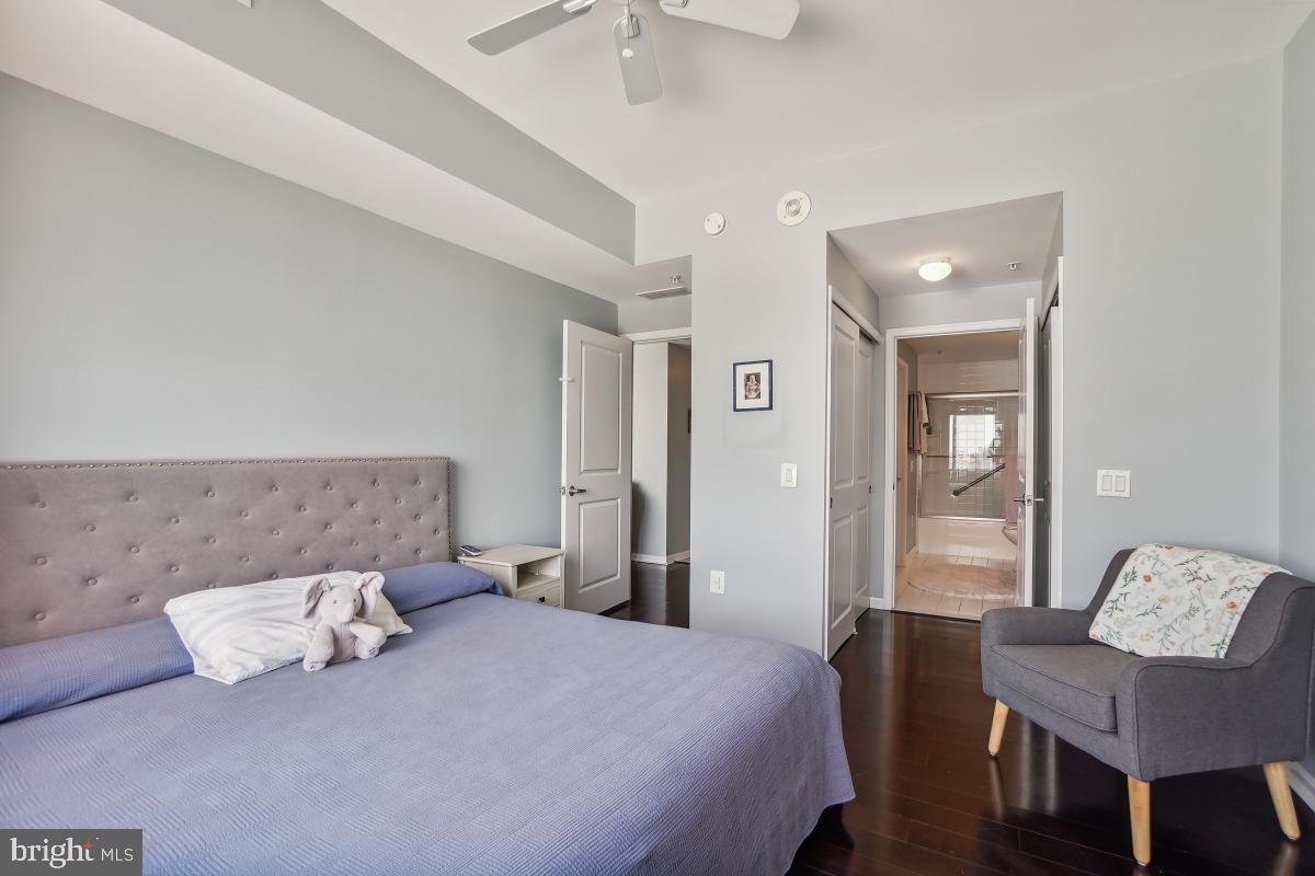 930 Wayne Avenue, Unit 1407 Silver Spring, MD 20910 - Photo 23 of 31 a bedroom with a bed and wooden floor