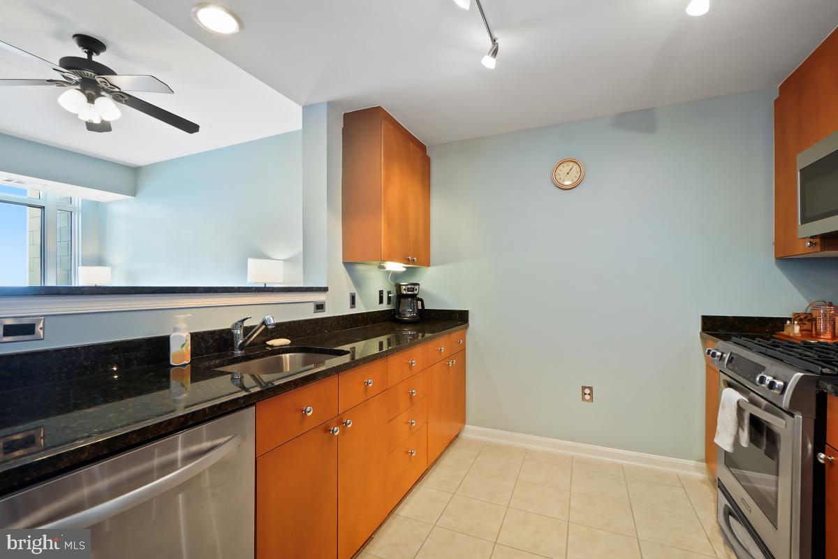 930 Wayne Avenue, Unit 1407 Silver Spring, MD 20910 - Photo 5 of 31 a kitchen with granite countertop a sink a stove and cabinets