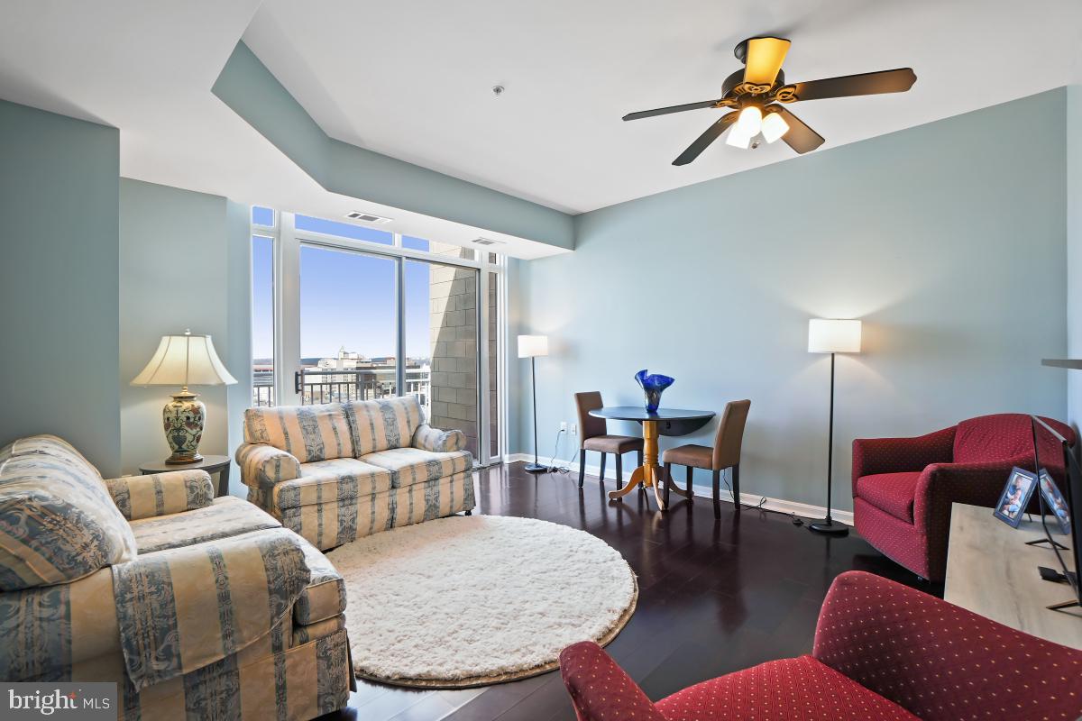 930 Wayne Avenue, Unit 1407 Silver Spring, MD 20910 - Photo 10 of 31 a living room with furniture a dining table and a chandelier