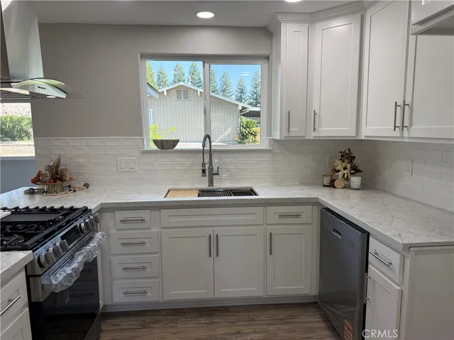 a kitchen with stainless steel appliances granite countertop a sink stove and cabinets