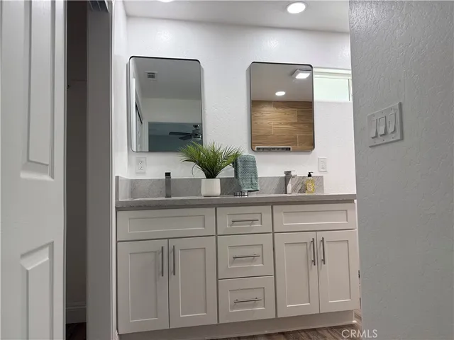 an empty room with wooden floor a ceiling fan and windows