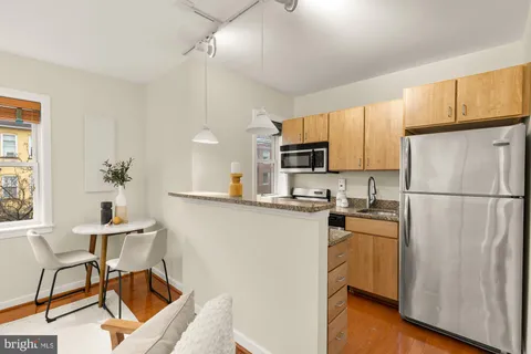 a kitchen with cabinets stainless steel appliances and a refrigerator