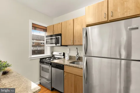 a kitchen with stainless steel appliances granite countertop a refrigerator sink and cabinets