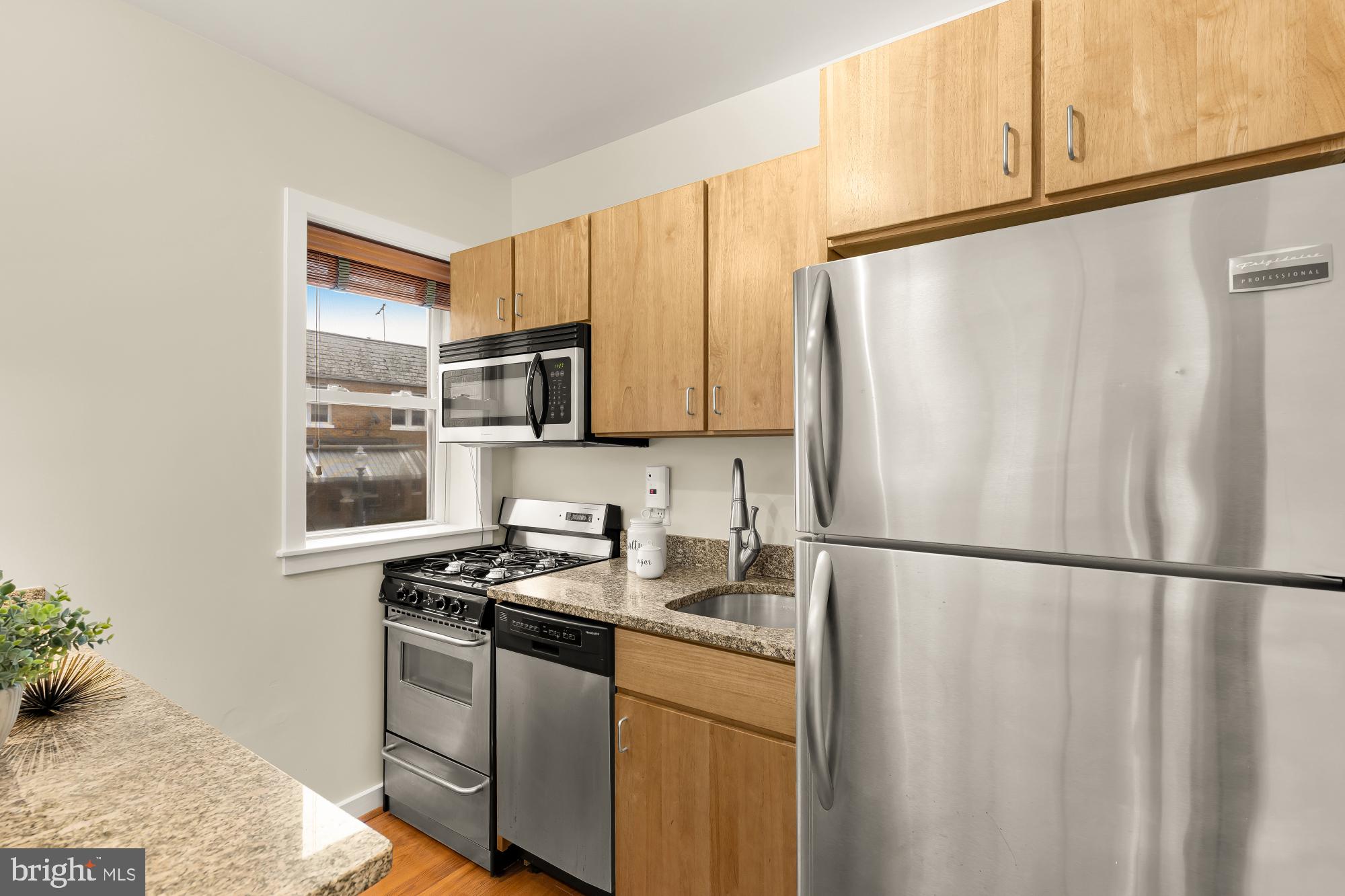 3534 10th Street Northwest, Unit 200 Washington, DC 20010 - Photo 12 of 34 a kitchen with stainless steel appliances granite countertop a refrigerator sink and cabinets