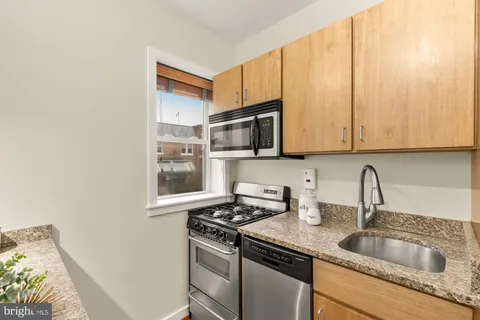 a kitchen with stainless steel appliances granite countertop a sink stove and microwave