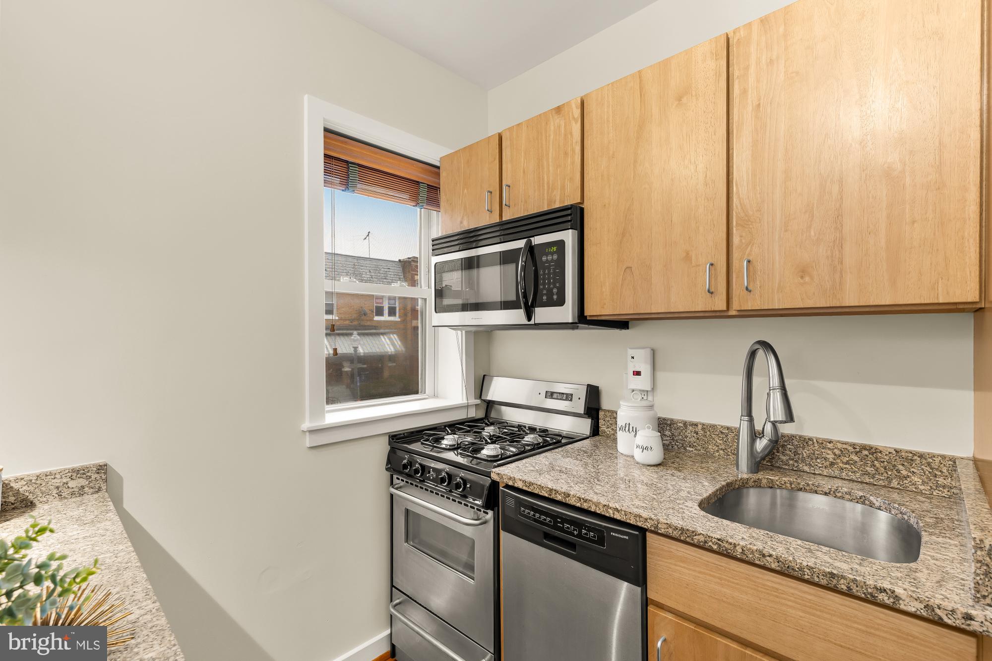 3534 10th Street Northwest, Unit 200 Washington, DC 20010 - Photo 13 of 34 a kitchen with stainless steel appliances granite countertop a sink stove and microwave
