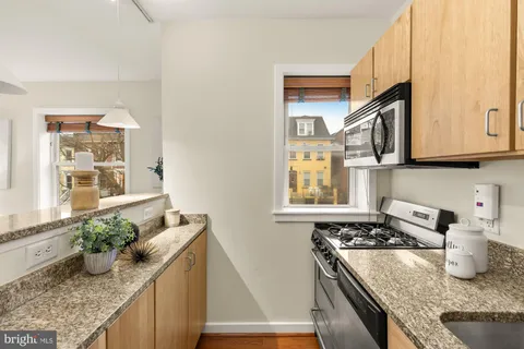 a kitchen with granite countertop a stove a sink and a granite counter tops