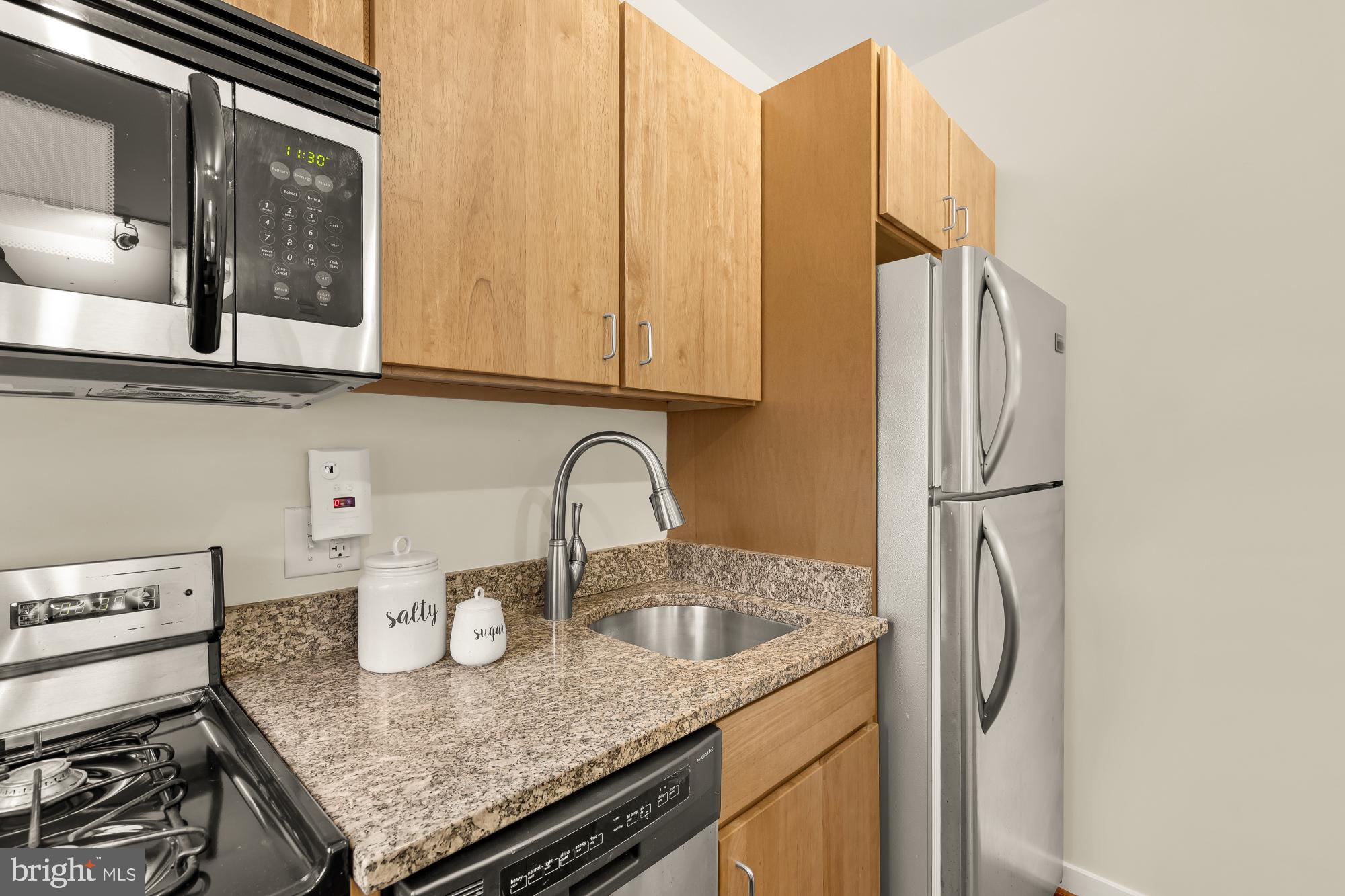 3534 10th Street Northwest, Unit 200 Washington, DC 20010 - Photo 17 of 34 a kitchen with stainless steel appliances granite countertop a sink and a refrigerator