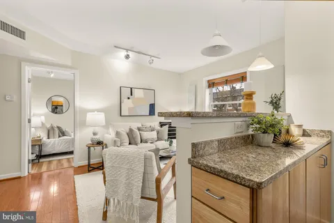 a living room with granite countertop kitchen island furniture and a wooden floor