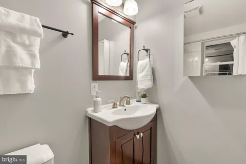 a bathroom with a sink a toilet and a mirror