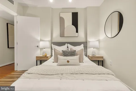 a bedroom with a bed and a lamp on dresser