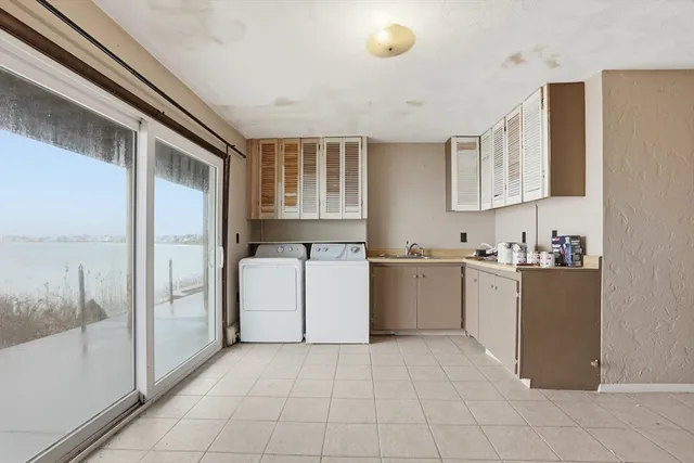 a kitchen with a refrigerator and white cabinets