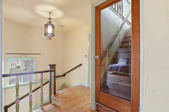 a view of a hallway with wooden floor and staircase