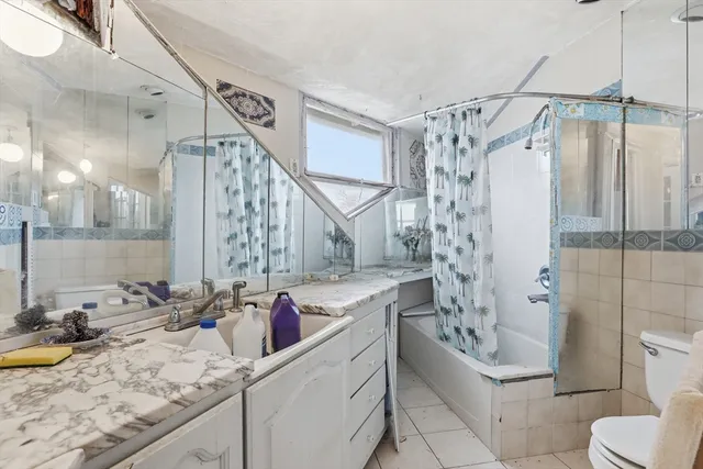 a bathroom with a granite countertop sink a toilet and shower