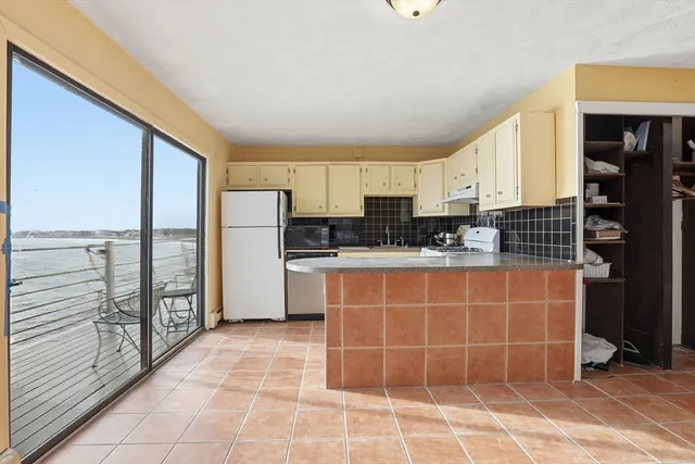 a kitchen with stainless steel appliances a sink a counter top space cabinets and a large window