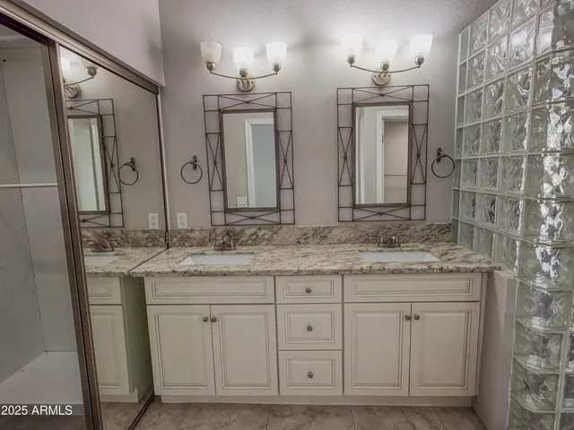 a bathroom with double sink and a mirror