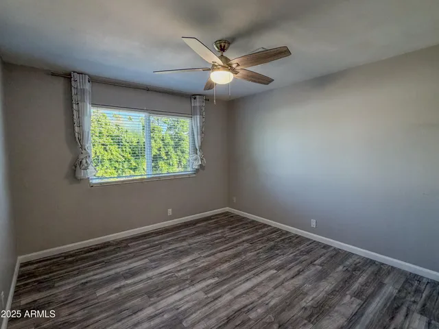en empty room with window and ceiling fan