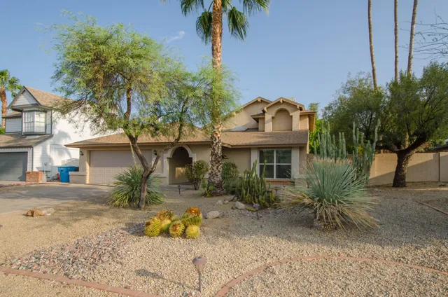 a front view of house with yard and trees around