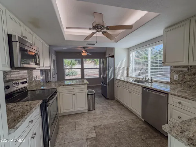 a kitchen with granite countertop a stove sink and microwave