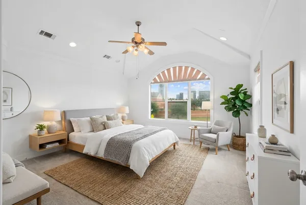 a bedroom with a bed a chandelier and a flat screen tv