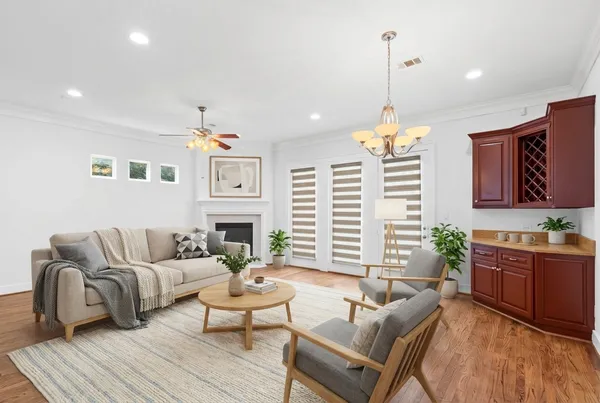 a living room with furniture a fireplace and a chandelier
