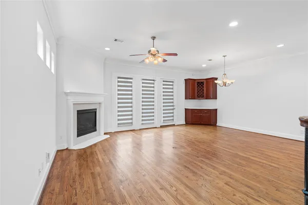 an empty room with wooden floor fireplace and windows