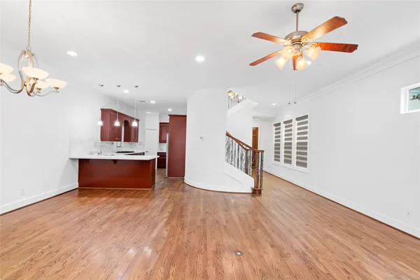 a living room with stainless steel appliances kitchen island granite countertop a wooden floor
