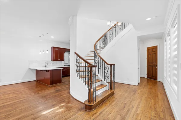 a view of a hallway with wooden floor and staircase