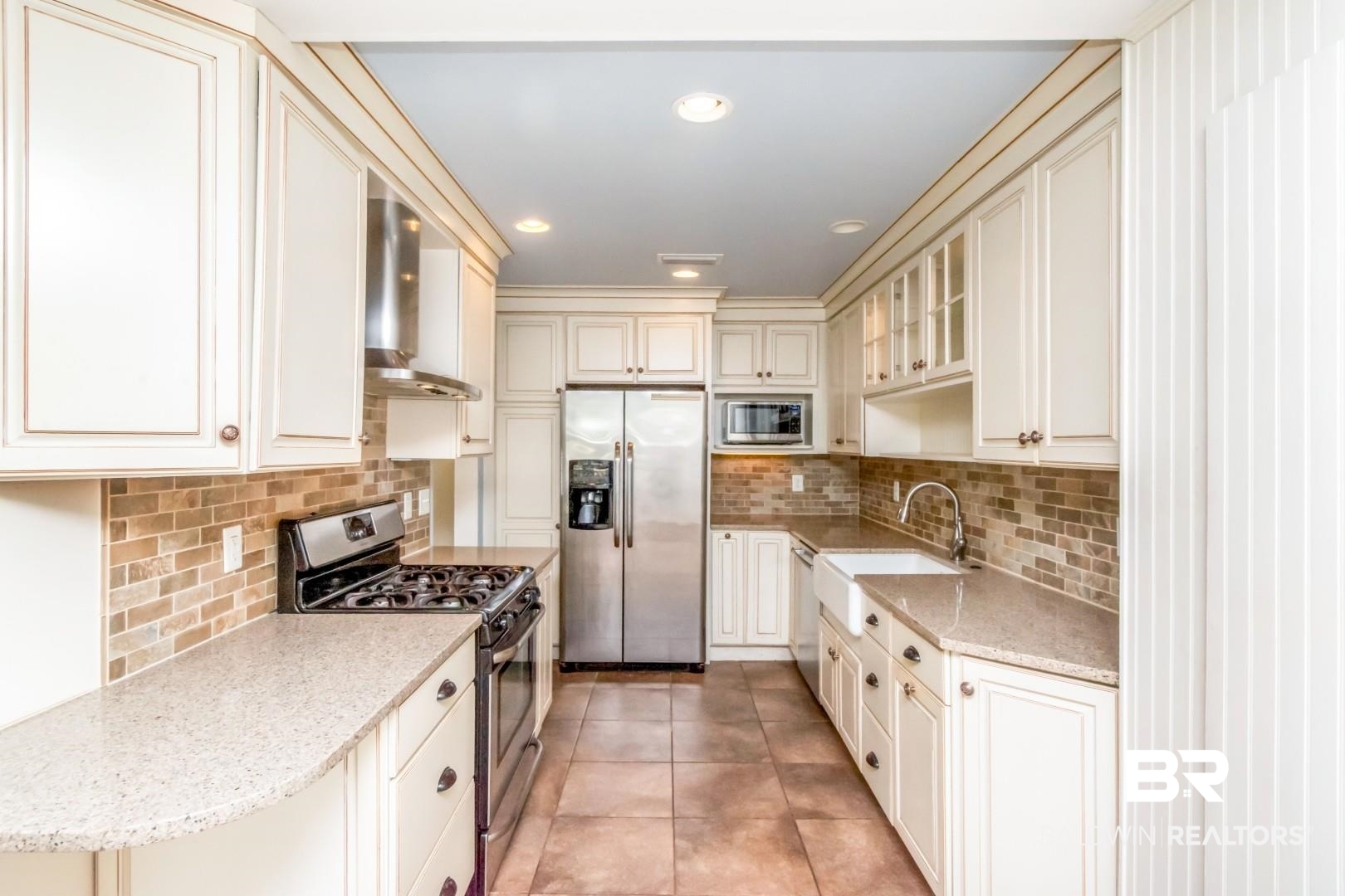 10 South Hathaway Road Mobile, AL 36608 - Photo 10 of 46 Kitchen with appliances with stainless steel finishes, glass insert cabinets, light stone countertops, wall chimney exhaust hood, and recessed lighting
