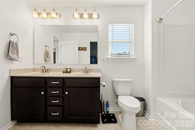 a bathroom with a sink vanity mirror and toilet