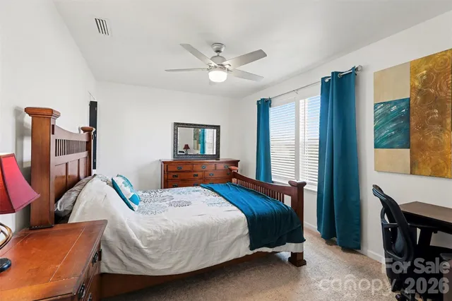 a bedroom with a bed wooden floor and window