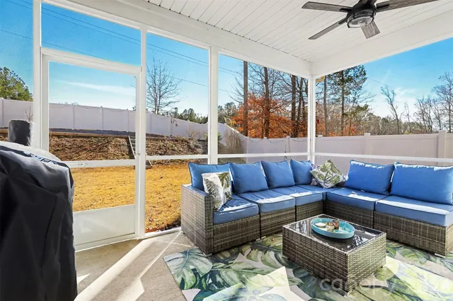 a living room with furniture and a floor to ceiling window