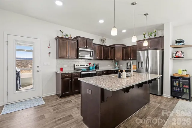 a kitchen with stainless steel appliances granite countertop a sink refrigerator and cabinets