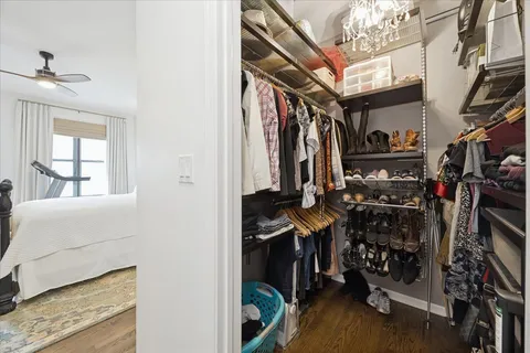 a view of walk in closet with clothes and shoes