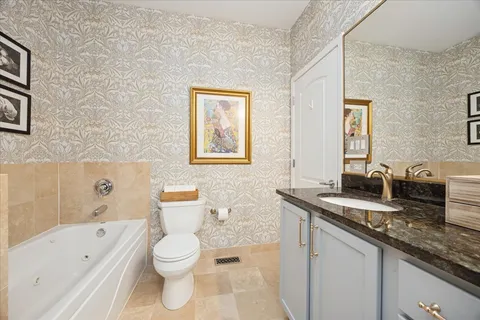 a bathroom with a granite countertop sink a toilet and bathtub