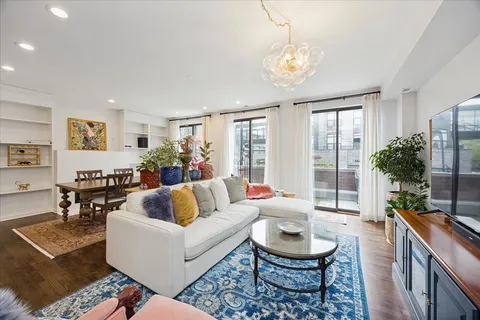 a living room with fireplace furniture and a large window