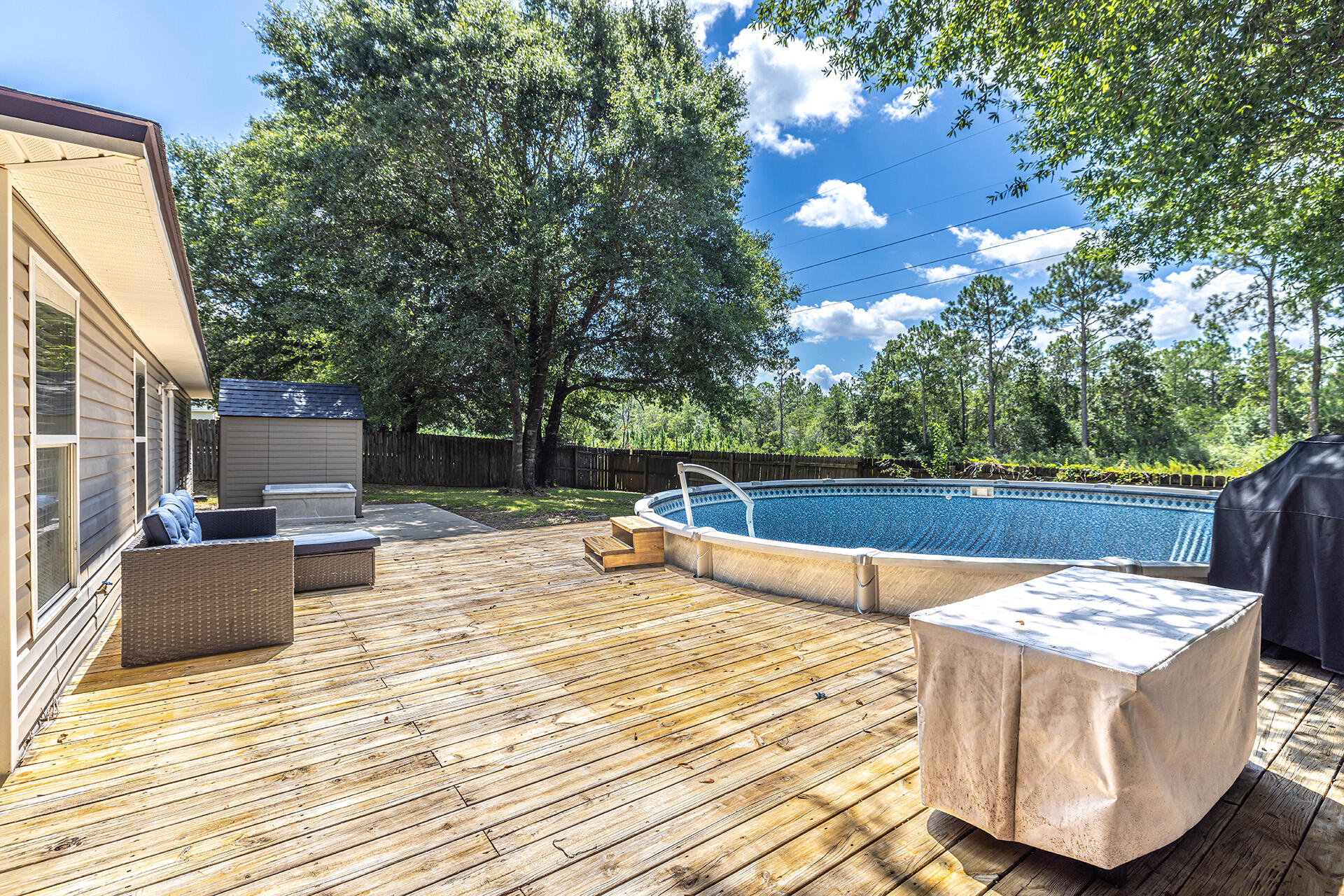 201 Lustan Drive Crestview, FL 32536 - Photo 11 of 34 a view of a patio with dining table and chairs with wooden floor and fence