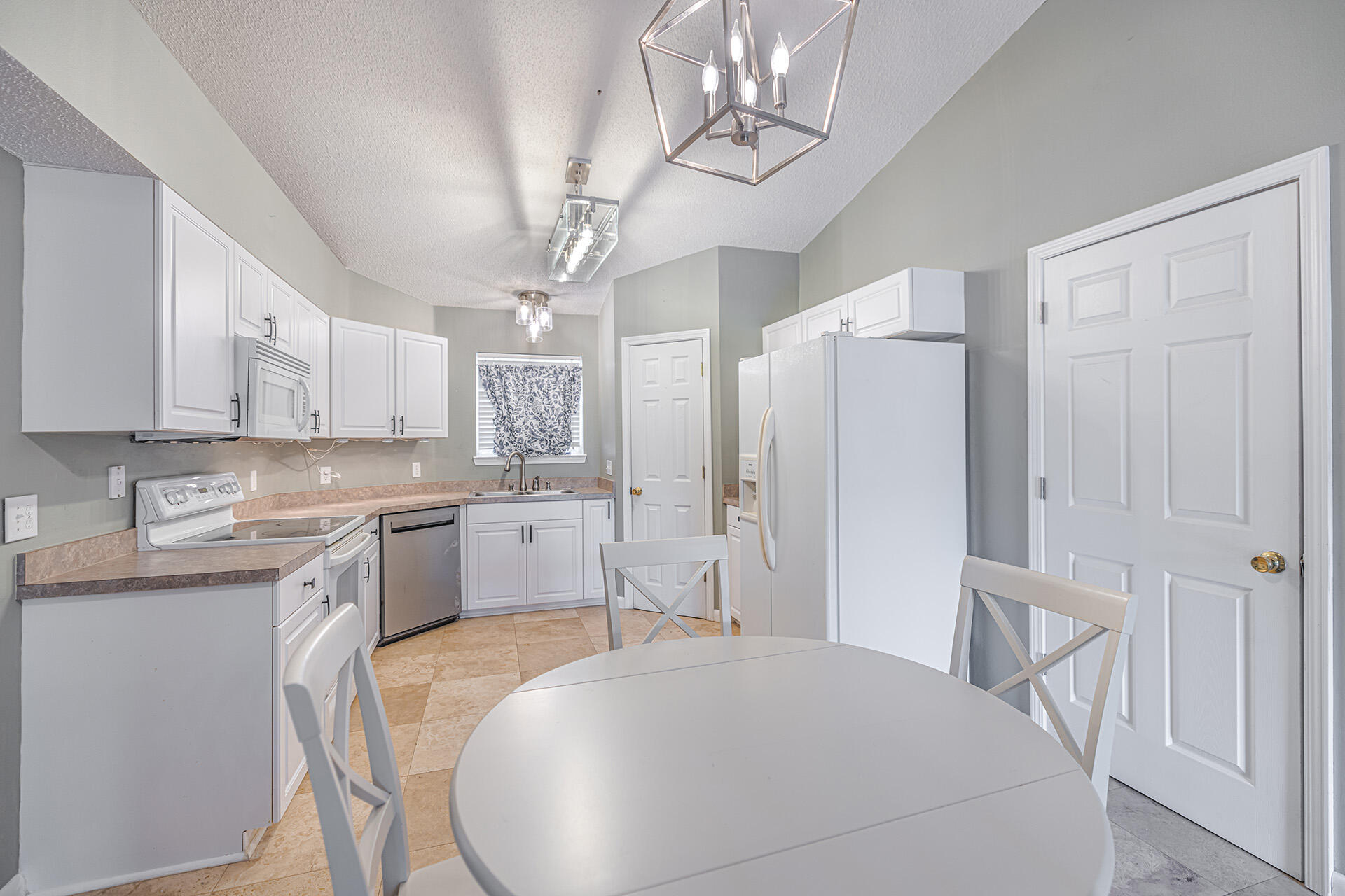 201 Lustan Drive Crestview, FL 32536 - Photo 21 of 34 a kitchen with a table chairs refrigerator and cabinets