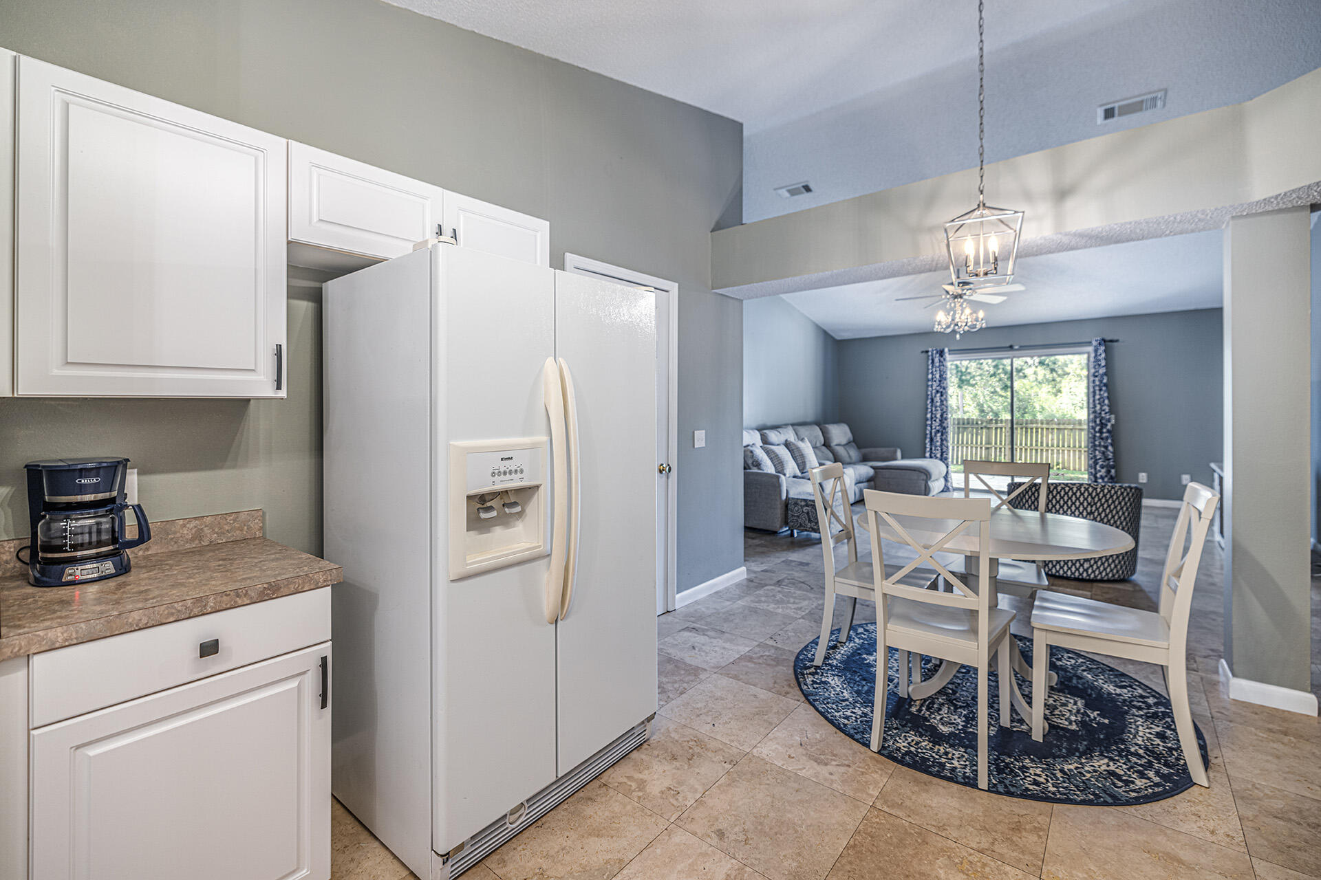 201 Lustan Drive Crestview, FL 32536 - Photo 22 of 34 a kitchen with kitchen island granite countertop a refrigerator a stove a dining table and chairs with wooden floor