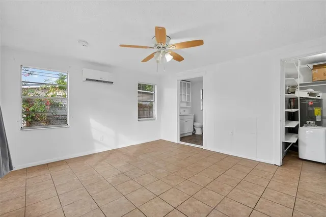 a view of empty room with window and ceiling fan