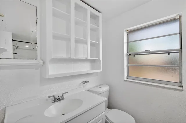 a bathroom with a sink mirror and toilet
