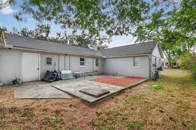 a front view of house with yard outdoor seating and covered with trees