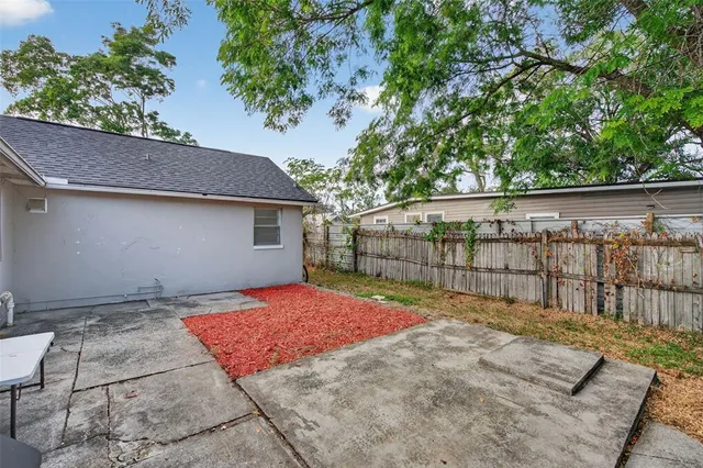 a view of backyard with wooden fence