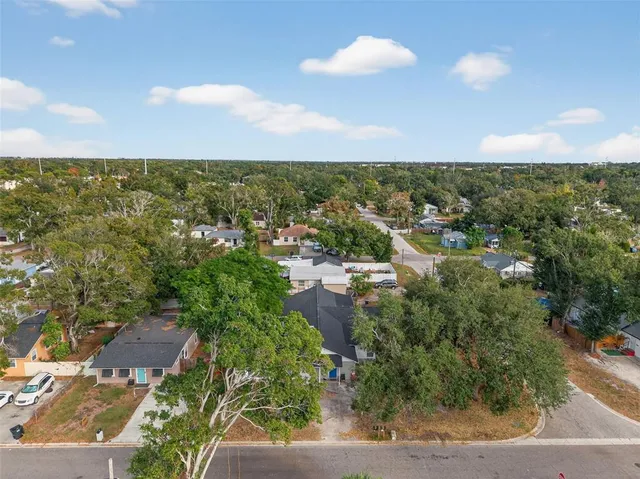 an aerial view of residential houses with outdoor space and trees